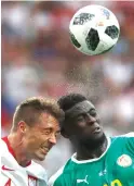  ?? Darko Vojinovic/ Associated Press ?? ■ Poland's Thiago Cionek, left, and Senegal's Alfred Ndiaye, right, go for a header during the group H match between Poland and Senegal on Tuesday at the 2018 soccer World Cup in Moscow.