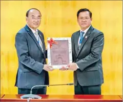  ?? NA ?? Loy Sophat (left), NA planning commission head, meets with Laos’ Vongsack Phanthavon in Laos on December 3.