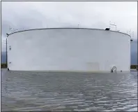  ?? (Bloomberg (WPNS)/Mark Felix) ?? An oil tank is surrounded by water in September after Hurricane Ida near Cocodrie, La.