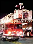  ?? Westside Eagle Obseerver/RANDY MOLL ?? Santa appeared in the bucket of a Gentry Fire Department ladder truck at the close of the Gentry Christmas Parade in downtown Gentry on Saturday night.