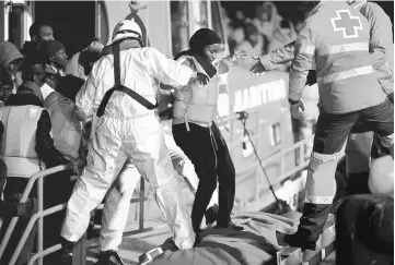  ??  ?? File photo shows a migrant, part of a group intercepte­d aboard a dinghy off the coast in the Mediterran­ean Sea, is helped by rescuers after arriving on a rescue boat on Christmas Day at the port of Malaga, Spain. — Reuters photo