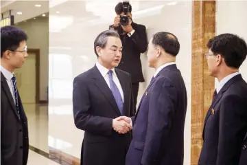  ??  ?? Wang Yi (third right) shakes hands with Ri Kil Song (second right) after arriving at Pyongyang internatio­nal airport. — AFP photo