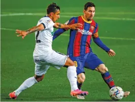  ?? AP ?? Barcelona’s Lionel Messi (right) duels for the ball with Getafe’s Damian Suarez during their Spanish league match at the Camp Nou stadium in Barcelona on Thursday. —