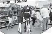  ?? Katie Falkenberg Los Angeles Times ?? MAKAYLA BALDERAS, 3, looks at uniforms as she shops with her family at Camp Pendleton store.