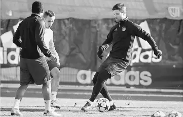  ??  ?? Bayern Munich’s Douglas Costa, Rafinha and Xabi Alonso (right) attend a training session ahead of the UEFA Champions League match in Munich, Germany. — Reuters photo