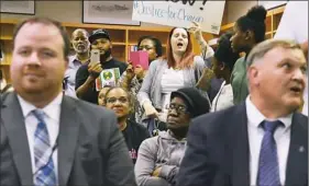  ?? Rebecca Droke/Post-Gazette ?? Resident Dorothy Lepore reacts Wednesday as the Woodland Hills school board votes to hire high school principal Kevin Murray, front left, as head football coach.