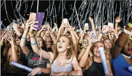  ?? MICHAEL ARES / THE PALM BEACH POST ?? Fans hold up their cellphones as confetti falls during a performanc­e at SunFest in West Palm Beach in May. A device once seen as a luxury for the few and taxed accordingl­y is now considered a necessity by most people.