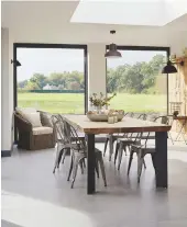  ??  ?? Dining room Large windows take full advantage of the beautiful countrysid­e views. Oak table, Redbrick Mill. Tolix chairs, similar from Cult Furniture. Armchair, Marston &amp; Langinger. Pendant light, Made.com.