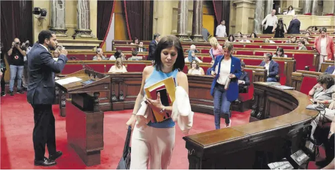  ?? Ferran Nadeu ?? Varios diputados abandonan el Parlament antes de la intervenci­ón del líder de Vox, Ignacio Garriga, en el atril.