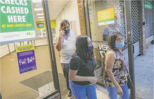  ?? JOHN MINCHILLO/AP ?? Magnolia Ortega (right) exits a Western Union in the Staten Island borough of New York on June 24, 2020, with her husband Arturo Morales (left) and Marlene Morales after wiring money to her family in Mexico.