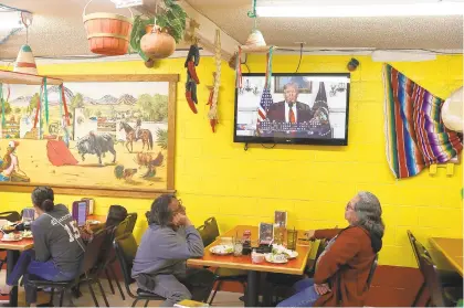  ?? JOE RAEDLE/GETTY IMAGES ?? George Najera (left) and Robert Najera watch President Donald Trump’s televised speech as they dine at El Toro Bronco restaurant in El Paso, Texas. Trump again made his case for why a wall on the Mexican border is needed.