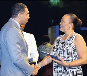  ??  ?? Prime Minister Andrew Holness presents former director of the Education System Transforma­tion Programme in the Ministry of Education, Youth and Informatio­n, Jean Hastings, with the Prime Minister’s Medal of Appreciati­on for Service to Education at the...