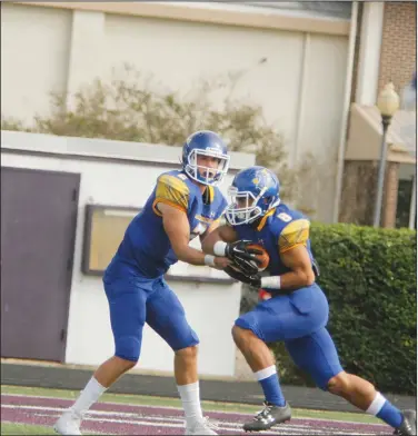  ?? Terrance Armstard/News-Times ?? On the move: Southern Arkansas quarterbac­k Barrett Renner hands the ball off to former Smackover standout Keiandre Purifoy during the Muleriders' contest against Ouachita Baptist during the 2017 Murphy USA Classic at Memorial Stadium. On Thursday, the Muleriders were picked to finish third in the Great American Conference in a poll of league coaches. The Tigers were picked to finish second with Harding being chosen to win the league.