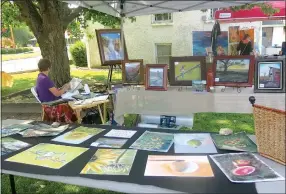  ?? Westside Eagle Observer/SUSAN HOLLAND ?? Artist Charlotte Childs, of Bella Vista, finds a shady spot under a tree behind the old Gravette Presbyteri­an Church to display her paintings in pastels and fine line drawings. Childs was one of several exhibitors in the annual Gravette Day art show. The show, organized by Michael Kelley, has become a popular part of the day’s events.