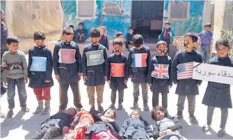  ??  ?? Silent protest Opposition activists shared this image of children in Idlib with tape over their mouths, with others playing dead, to signify the world’s silence over atrocities in Syria. One girl held a sign reading ‘Friends of Syria’ next to children...