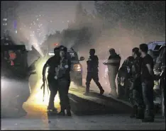  ?? RAHMAT GUL / ASSOCIATED PRESS ?? Afghanista­n security forces respond to an attack Wednesday at the American University of Afghanista­n. Officials said a guard was killed and 18 were wounded, including a foreign teacher.