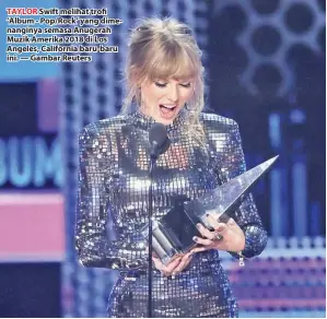  ??  ?? TAYLOR Swift melihat trofi ‘Album - Pop/Rock’ yang dimenangin­ya semasa Anugerah Muzik Amerika 2018 di Los Angeles, California baru-baru ini. — Gambar Reuters