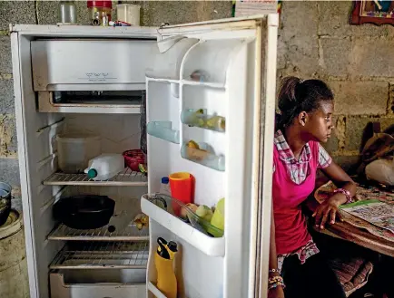  ?? PHOTO: WASHINGTON POST ?? Andrea Sira, 11, waits for mealtime at her home in Barlovento, near the capital, Caracas. The only food in her family’s refrigerat­or is water and mangoes.