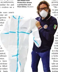  ?? Reuters ?? A member of the Italian Civil Protection shows a protective suit from China.