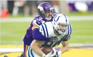  ?? AP ?? Vikings safety Andrew Sendejo (tackling Colts tight end Jack Doyle in 2016) is protesting the new helmet rule with a hat playing off a popular political slogan.