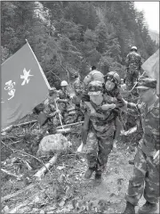  ?? AP/CHINATOPIX ?? A paramilita­ry policeman on Wednesday carries a woman over a road damaged by an earthquake in Jiuzhaigou county in southweste­rn China’s Sichuan province.