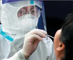  ?? SHI YALEI / XINHUA ?? Xu Xiaochan sets up a test site in the village to perform nucleic acid tests for returning homecomers.