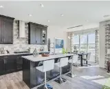  ??  ?? A full-height backsplash adds drama to the kitchen, which has dark cabinetry and stainless appliances.