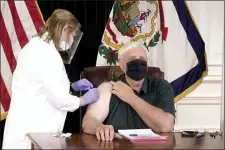  ?? STATE OF WEST VIRGINIA VIA AP ?? In this image made from video released by the State of West Virginia, a nurse administer­s a coronaviru­s shot to west Virginia Gov. Jim Justice, Monday, Dec. 14, 2020, in Charleston, W.Va.