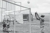  ?? Capt. Mikel Arcovitch / Associated Press ?? Army Pfc. Rafiou Affoh, a carpentry and masonry specialist, plays volleyball with Afghan evacuees at Camp Liya.