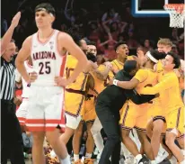  ?? RICK SCUTERI/AP ?? As Arizona’s Kerr Kriisa (25) stands stunned, Arizona State guard Desmond Cambridge Jr. celebrates with teammates after hitting a 3-point buzzer-beater to defeat the Wildcats in Tucson.