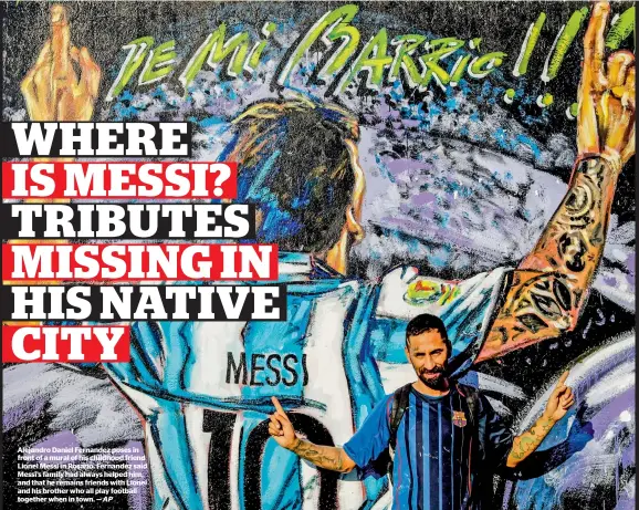  ?? — AP ?? Alejandro Daniel Fernandez poses in front of a mural of his childhood friend Lionel Messi in Rosario. Fernandez said Messi’s family had always helped him, and that he remains friends with Lionel and his brother who all play football together when in...