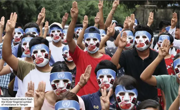  ??  ?? Young demonstrat­ors flash the three-fingered symbol of resistance in Yangon