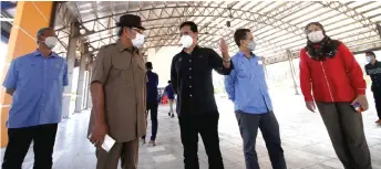  ?? — Bernama photo ?? Mohd Fasiah (centre) speaks with Pasir Salak MP Datuk Seri Tajuddin Abdul Rahman during the working visit to the Kampung Gajah My Rakyat and Permanent Farmers’ Market, which is expected to be operationa­l this coming March.