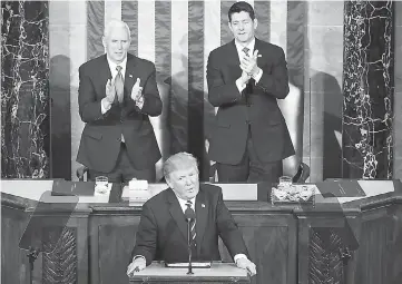  ??  ?? Trump addresses a joint session of the US Congress as Vice President Mike Pence (left) and House Speaker Rep. Paul Ryan (right) look on in the House chamber of the US Capitol in Washington, DC. — AFP photo