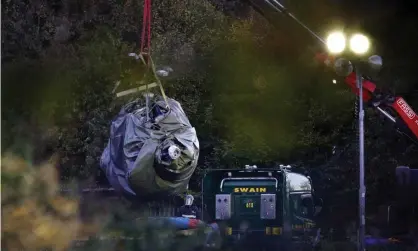  ??  ?? A crane removes wreckage of the the helicopter crash at Leicester City Football Club. Photograph: Aaron Chown/PA