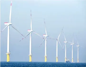  ??  ?? A service vessel is seen passing by wind turbines of the German offshore wind farm ‘Amrum Bank West’ owned by German energy company E.ON near the Helgoland archipelag­o on the North Sea. — AFP photo