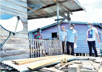  ??  ?? Shafie (second right) visiting one of the village houses at Tg Aru. Also seen is Junz (right).