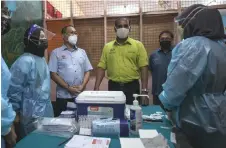  ?? Left) meet with health workers — Bernama photo ?? Awang (third left) and Saravanan (fourth carrying out the outreach programme.