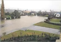  ?? PHOTO: HAYDEN MEIKLE ?? Kerb to kerb . . . Otter St in North Oamaru is inundated.