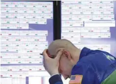  ??  ?? NEW YORK: Specialist Jarret Johnson works at his post on the floor of the New York Stock Exchange. —AP