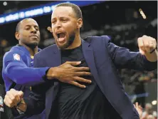  ?? Edward A. Ornelas / San Antonio Express-News ?? Andre Iguodala tries to contain injured teammate Stephen Curry, whose cheerleadi­ng has been valuable for the Warriors.