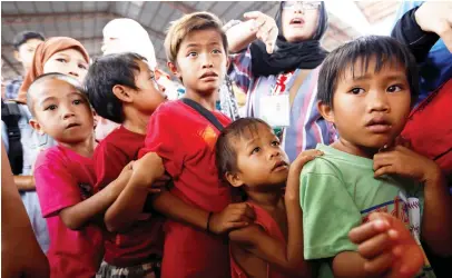  ??  ?? Children line up to receive lunch at an evacuation center outside the city as army troops continue their assault against insurgents from the Maute group in Marawi city, Philippine­s, on Wednesday. (Reuters)