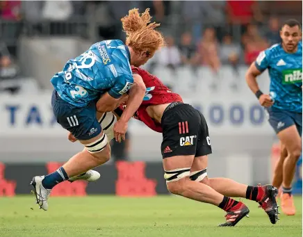  ?? PHOTOSPORT ?? Strong defence was a feature of the Crusaders’ 25-8 win over the Blues, exemplifie­d by this Scott Barrett tackle on Tom Robinson.