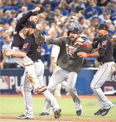  ??  ?? Indians reliever Cody Allen ( 37) is mobbed by teammates after recording the final out in Game 5 of the ALCS. | NATHAN DENETTE/ AP