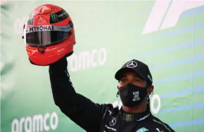  ?? Bryn Lennon/afp ?? Lewis Hamilton kreeg een helm van Schumacher: ‘Ik had nooit gedacht evenveel zeges te halen.’