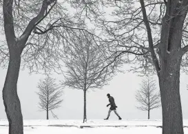 ?? CHARLES REX ARBOGAST/AP FILE ?? A runner leans into the wind in Chicago in 2021. A strengthen­ing El Nino means some snow lovers may be disappoint­ed this winter.