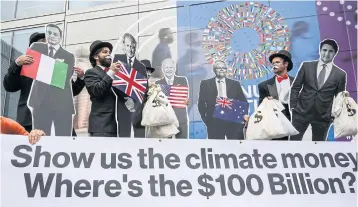  ?? AFP ?? Activists dressed as ‘debt collectors’ hold cutouts of the leaders of Italy, Mario Draghi; UK, Boris Johnson; US, Joe Biden; Australia, Scott Morrison; and Canada, Justin Trudeau in front of the IMF headquarte­rs in Washington on Wednesday.