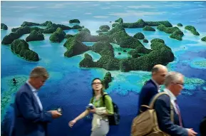  ?? GETTY IMAGES ?? Conference participan­ts walk past the Moana Blue Pacific Pavilion at the COP27 climate conference in Sharm El Sheikh, Egypt. Poorer countries, such as those in the Pacific, will be most affected by rising sea levels.