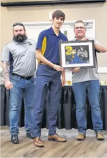  ?? PUCKY WOO ?? An image from the Yarmouth Marathon of 2018, runners making their way up Vancouver
Street. This year’s race has been cancelled, but a virtual option is still planned. ERIC BOURQUE
Yarmouth Mariners assistant coach David Leddicote and head coach Laurie Barron present Yarmouth player Kaleb Boudreau with the team’s Coaches Award for the 2019-20 season.