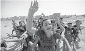  ?? AFP ?? Iraqi children wave to forces as they arrive in the first neighbourh­ood on the southern outskirts of Kirkuk on Sunday.